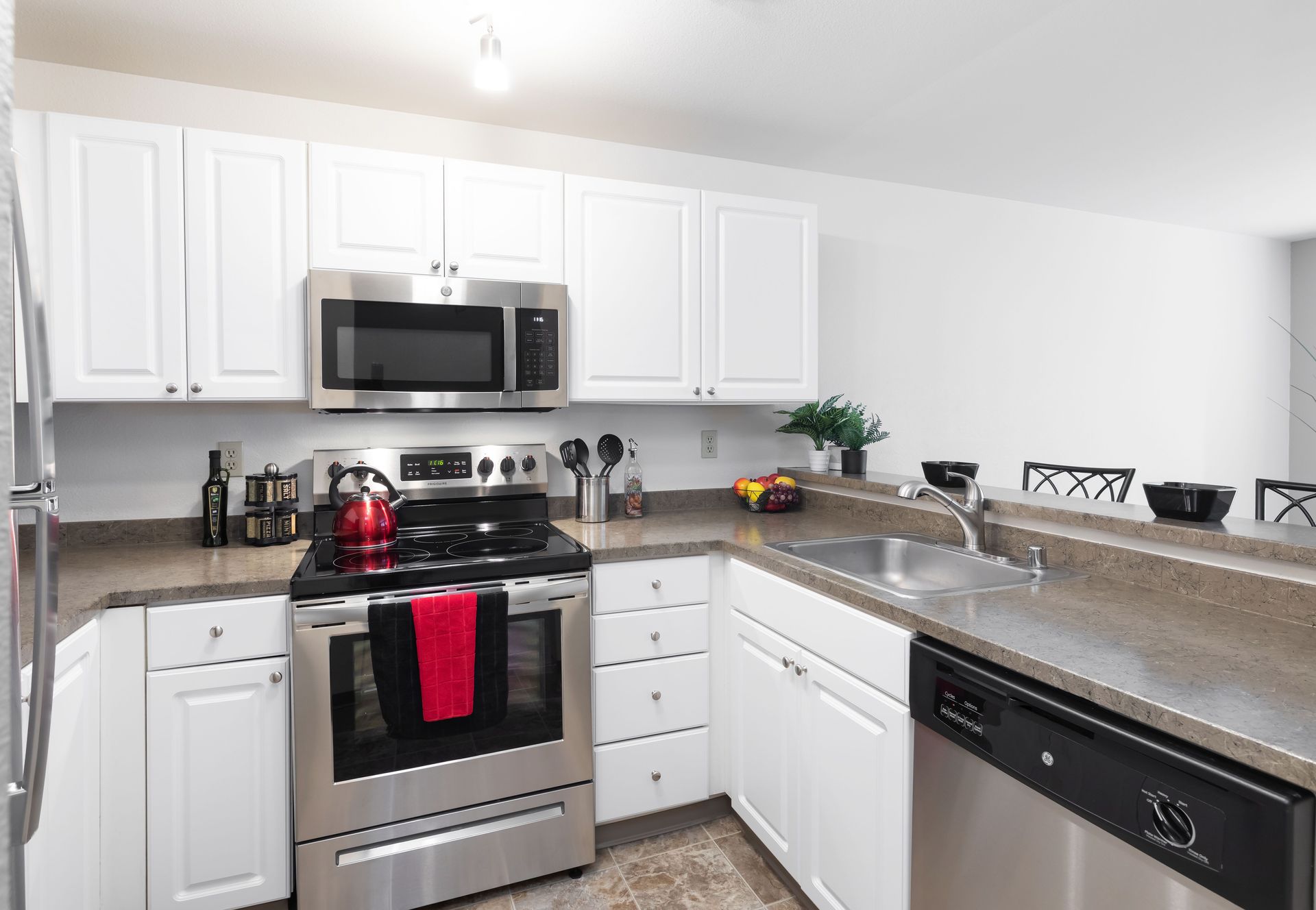 A kitchen with white cabinets and stainless steel appliances