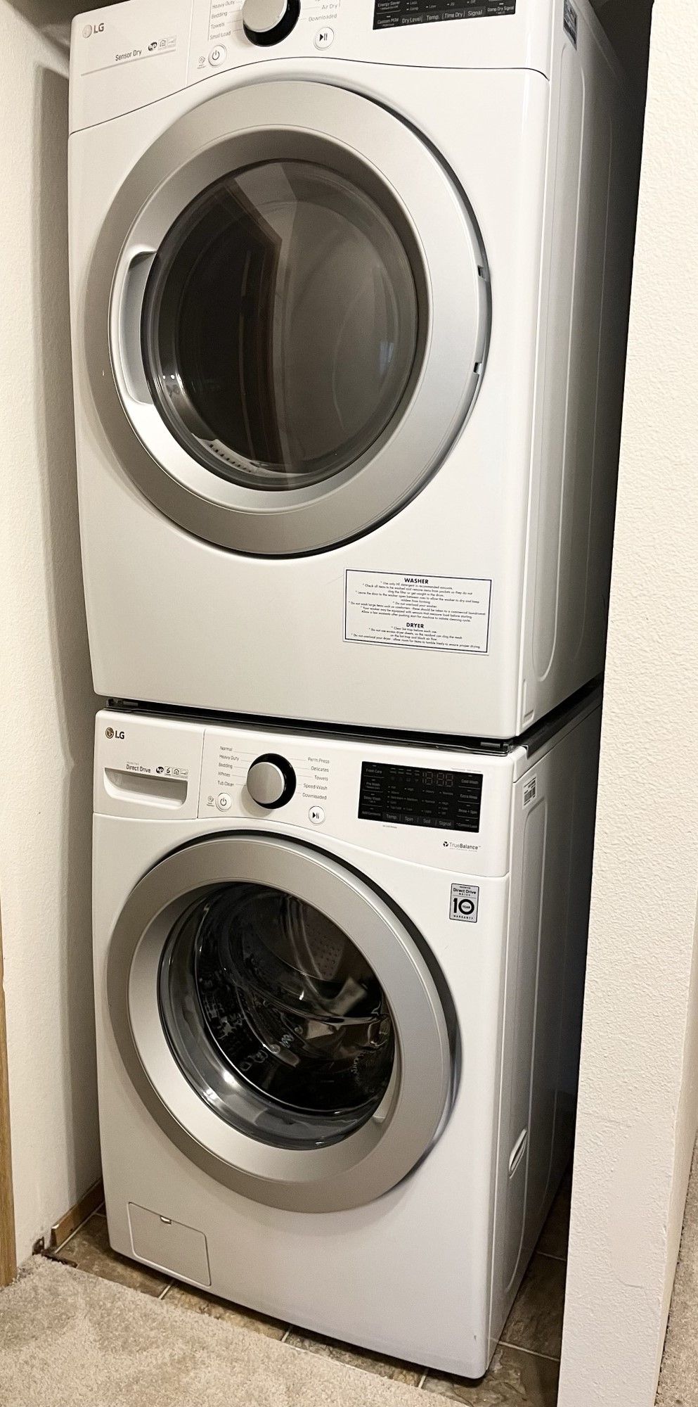 A washer and dryer are stacked on top of each other in a laundry room.