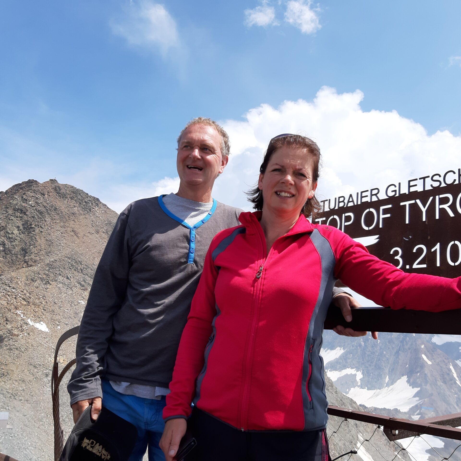 Een man en een vrouw staan ​​voor een bord met de tekst top of tyr