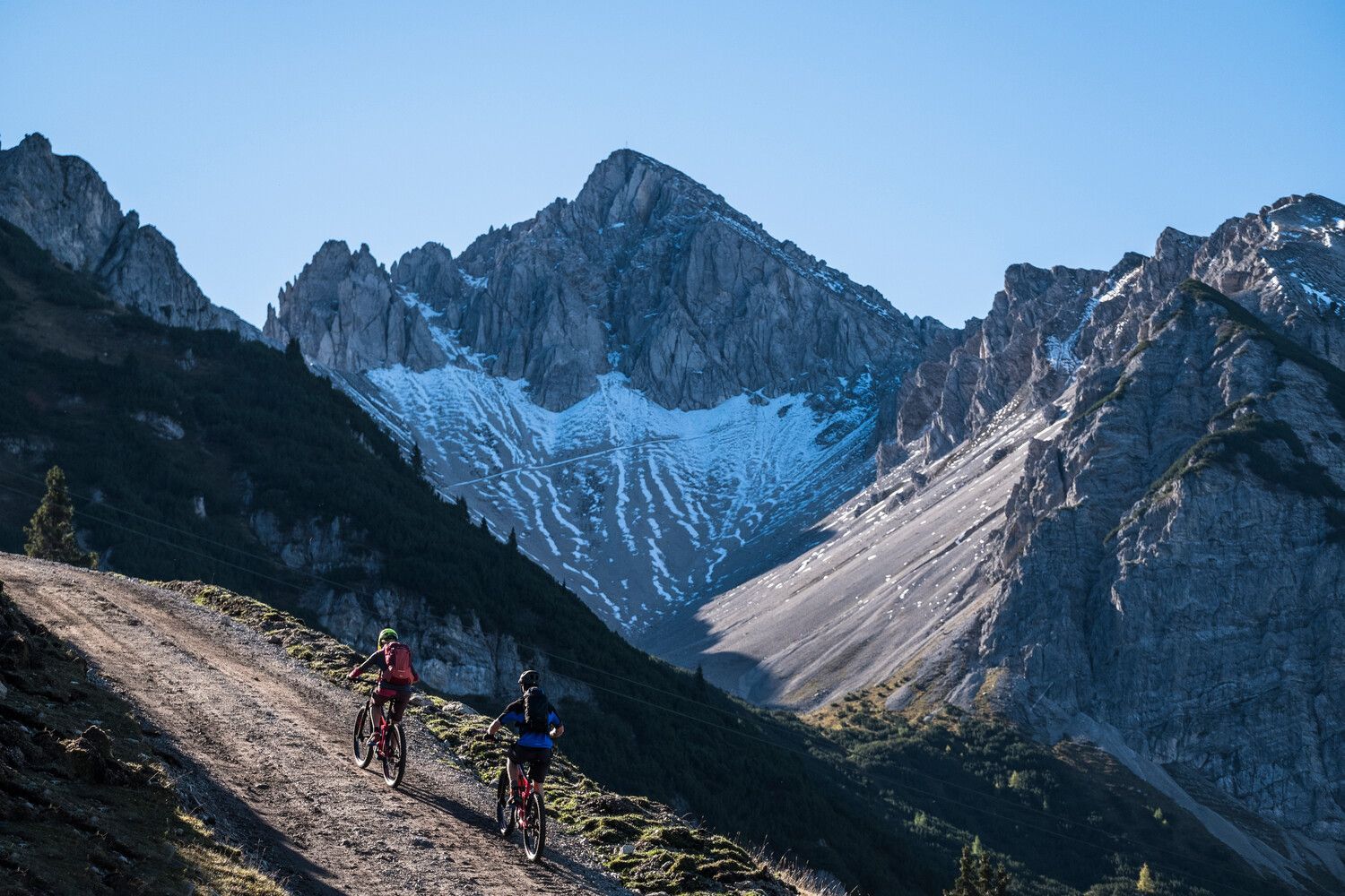 Eine Gruppe von Leuten fährt mit dem Fahrrad auf einem Pfad in den Bergen.