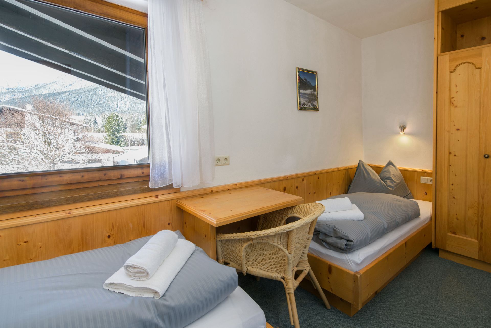 A bedroom with two beds , a desk and a window