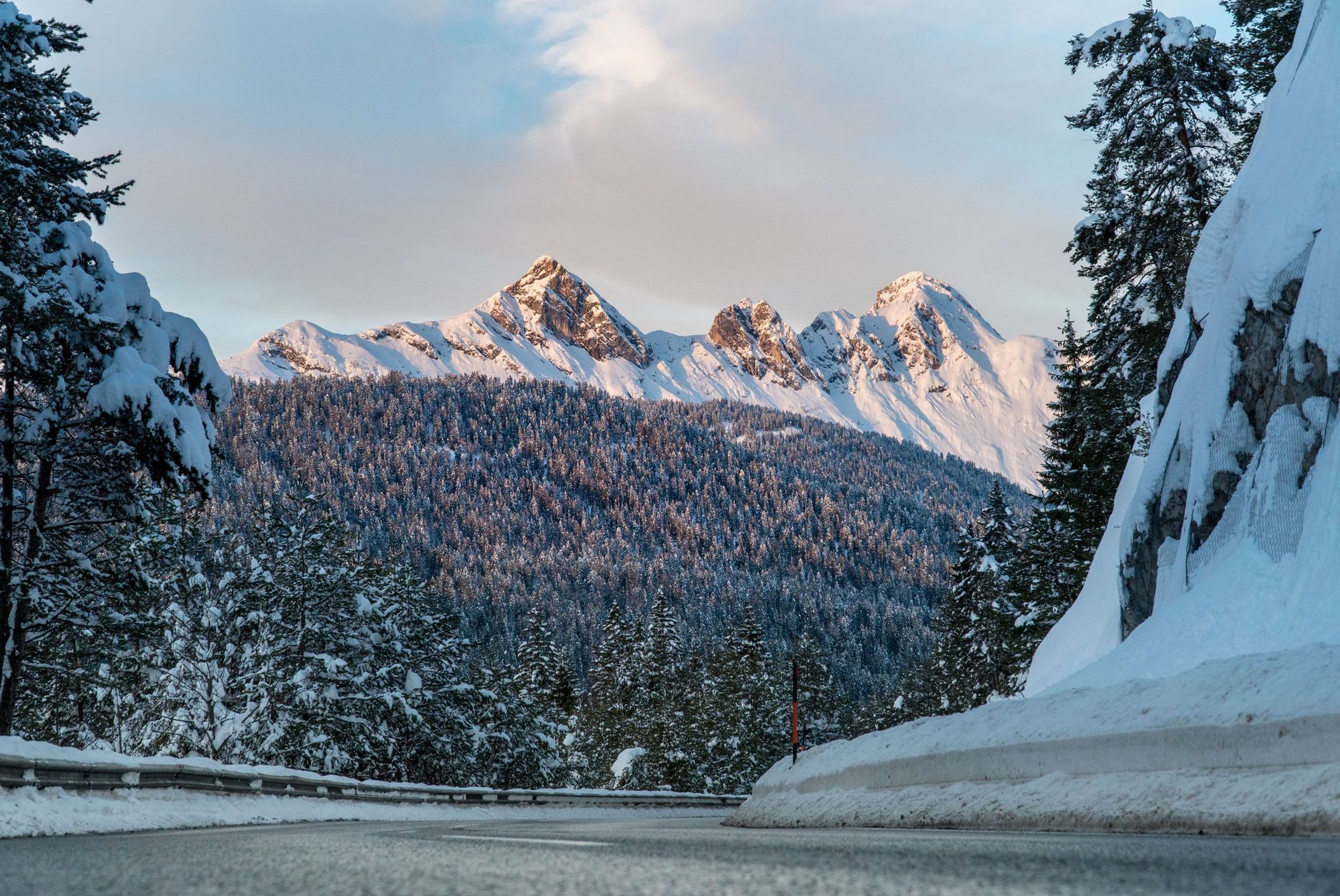 A snowy road with mountains in the background