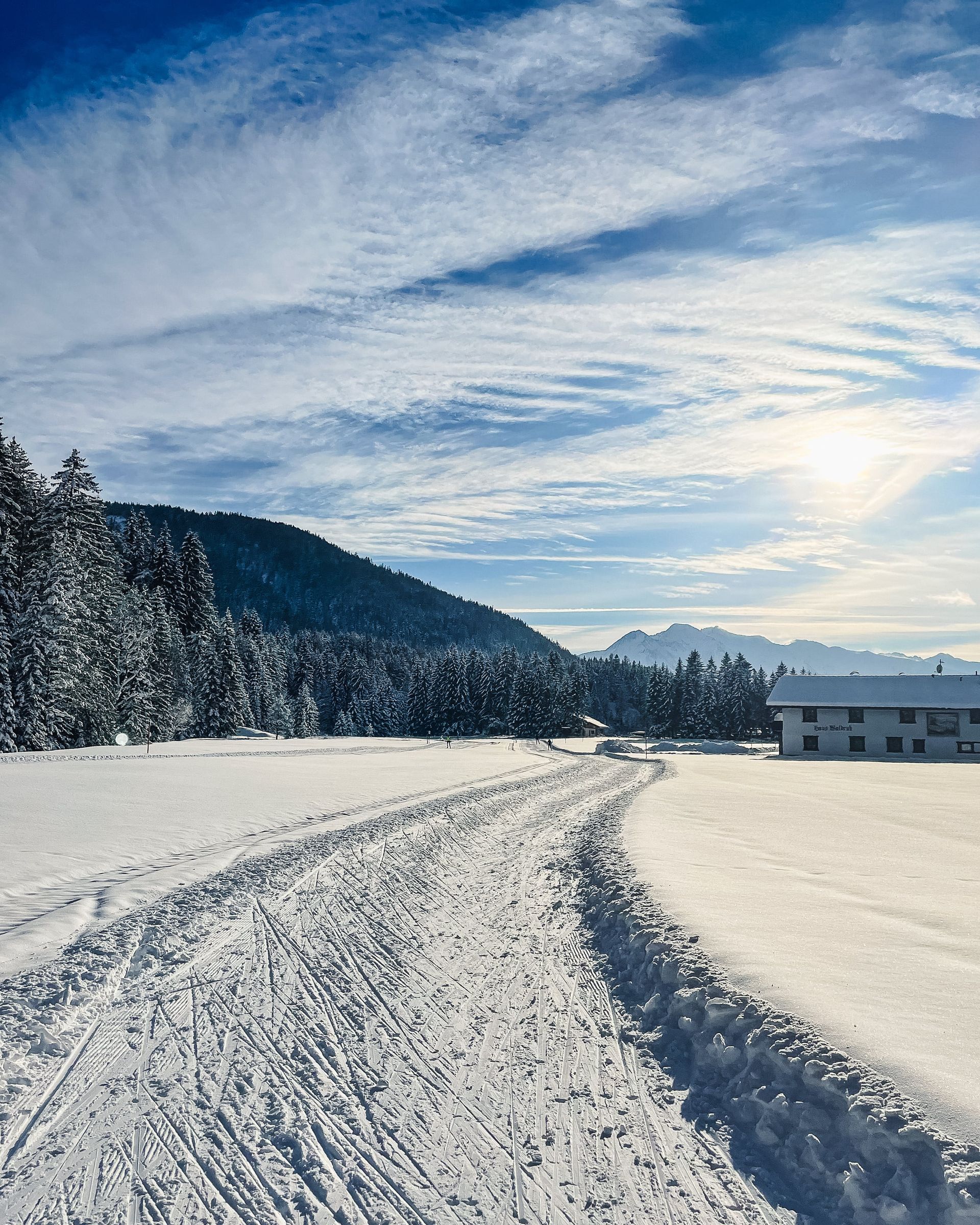 Eine verschneite Straße mit einem Haus im Hintergrund