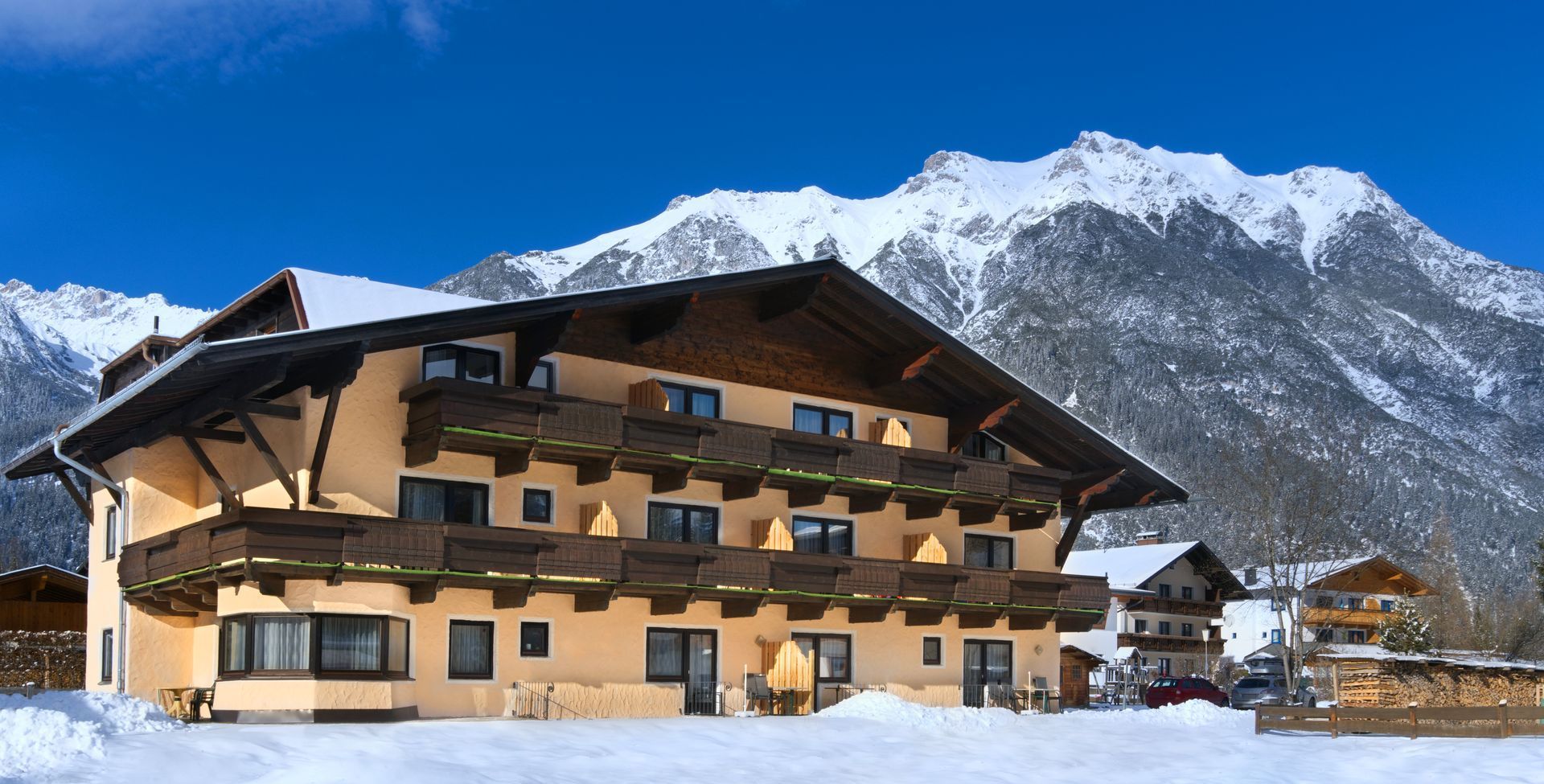 Ein großes Haus im Schnee mit Bergen im Hintergrund