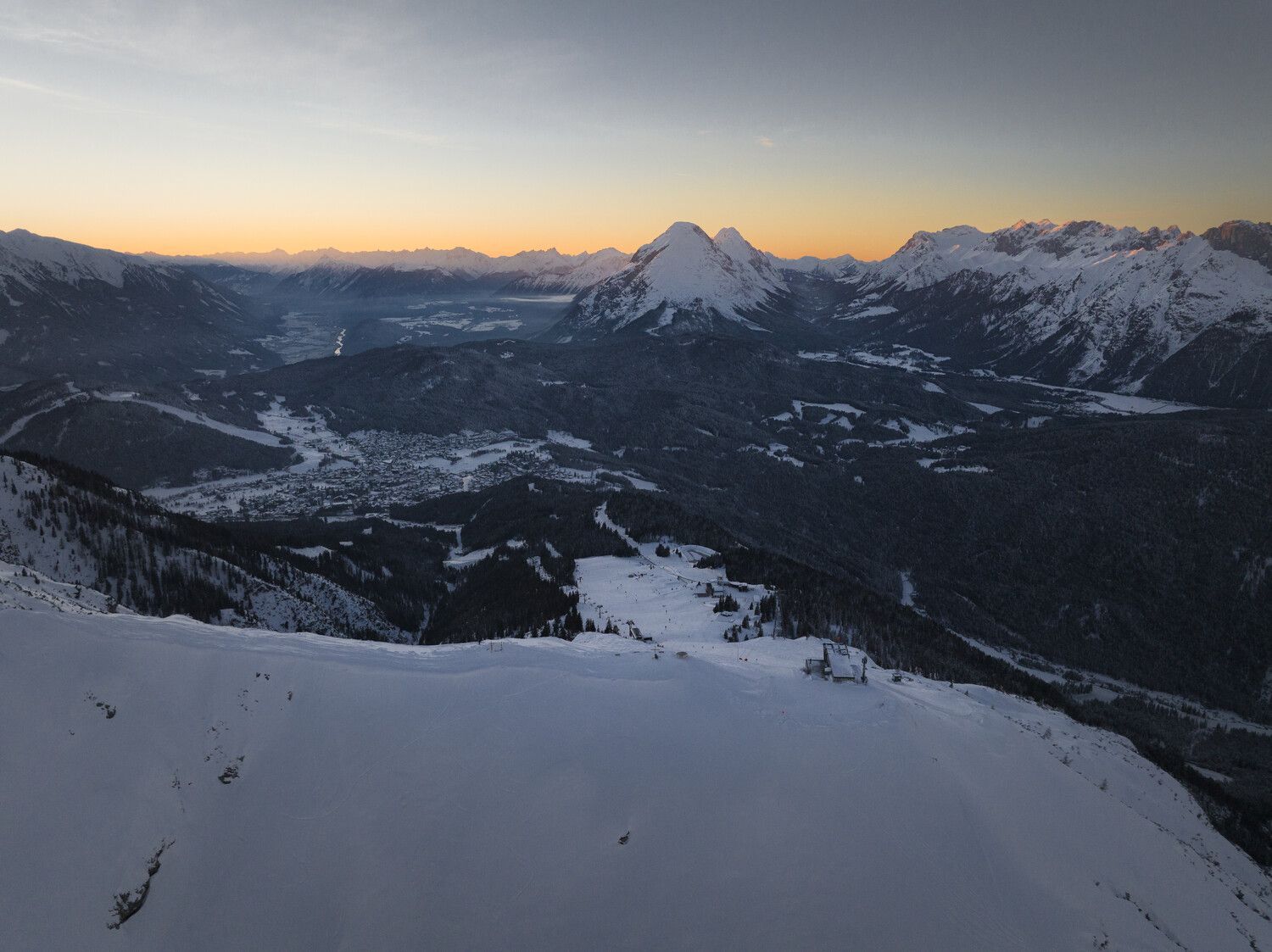 Ein Blick auf eine schneebedeckte Bergkette bei Sonnenuntergang.