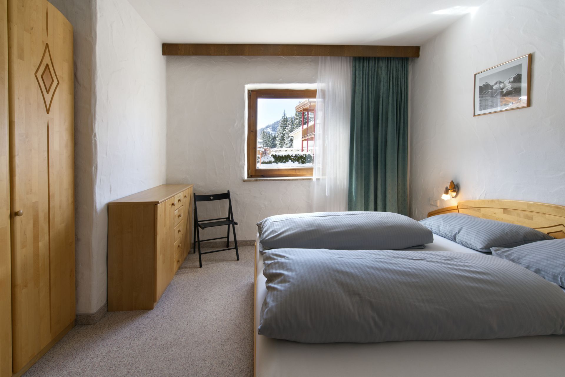 Een slaapkamer met twee bedden en een raam