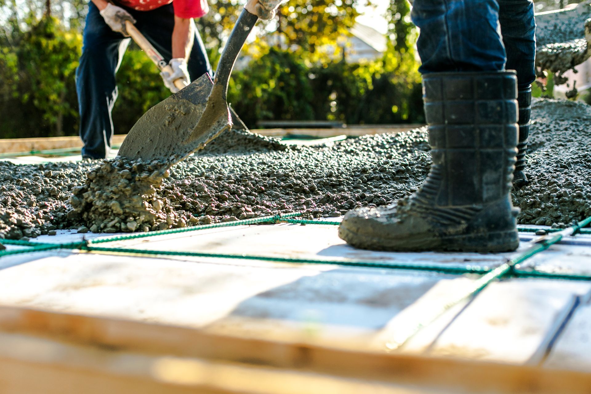 Two builders in the process of forming a house concrete slab at a construction site. Two builders in the process of forming a house concrete slab at a construction site.