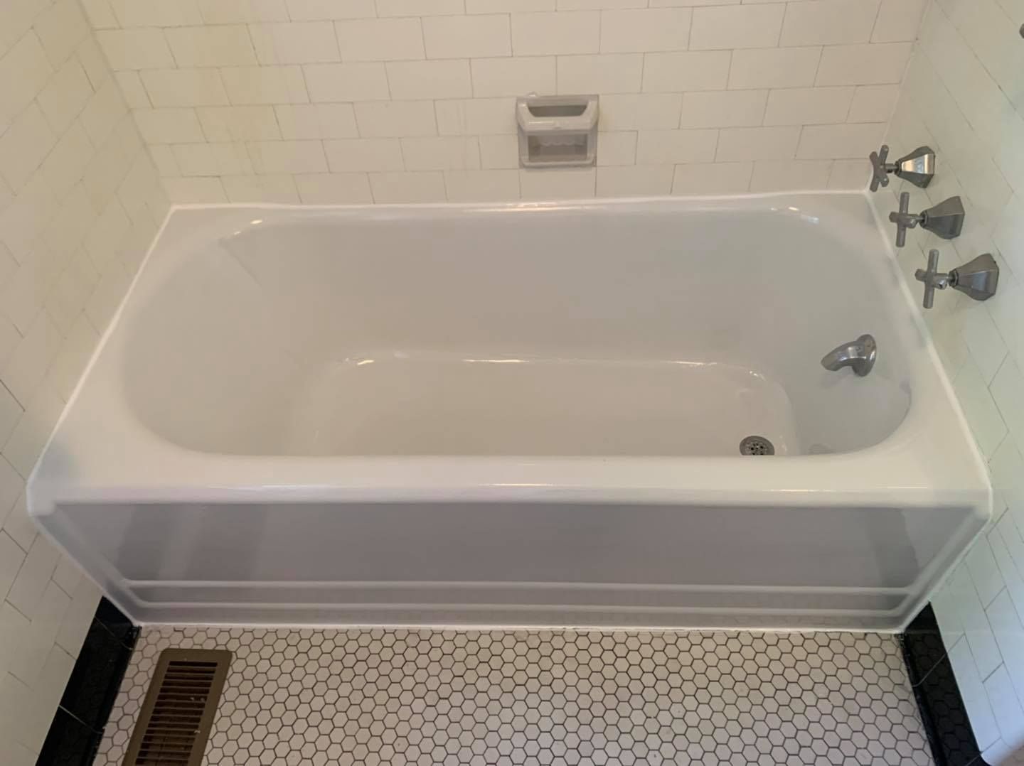 A white bathtub is sitting in a bathroom next to a tiled floor.