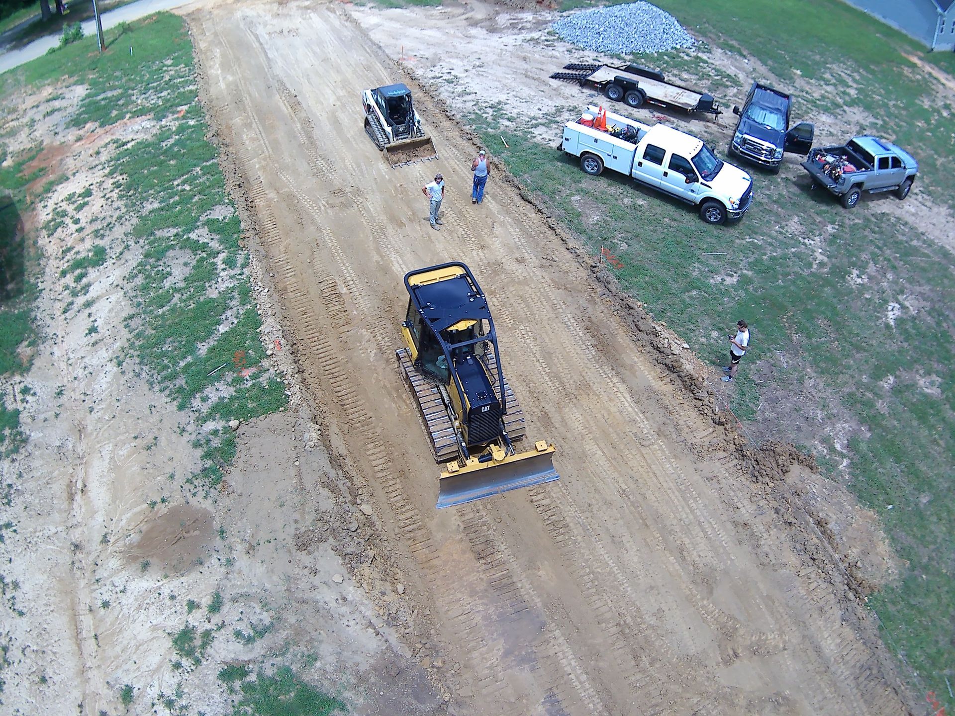An aerial view of a construction site with trucks and a bulldozer.