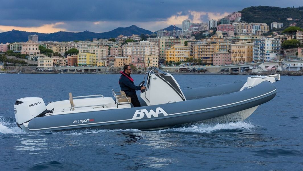 Un uomo guida una barca in acqua con una città sullo sfondo.