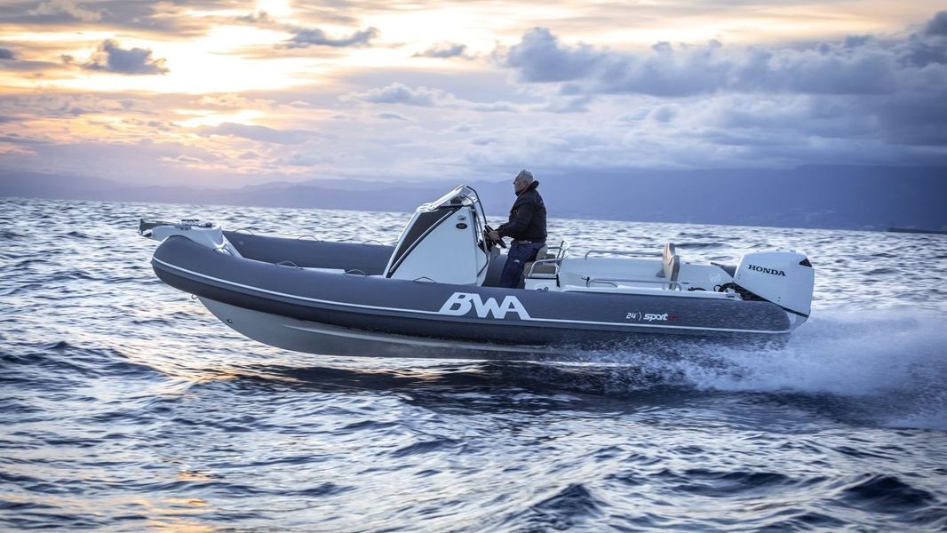 Un uomo sta navigando su una barca nell'oceano al tramonto.
