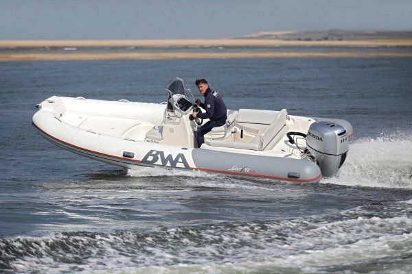 Un uomo sta guidando una barca che ha la scritta awa