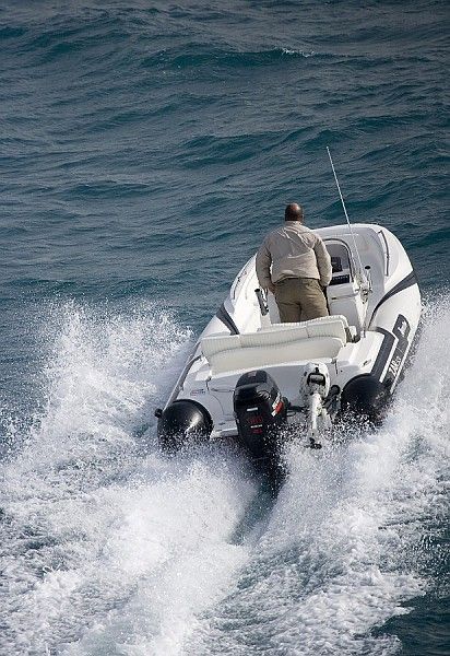 Un uomo sta viaggiando sul retro di una barca nell'oceano.