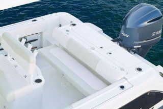 Una barca bianca con un motore Yamaha galleggia sulla superficie dell'acqua.
