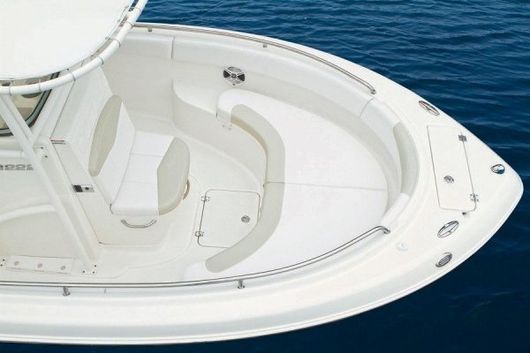 Una barca bianca galleggia sulla superficie di uno specchio d'acqua