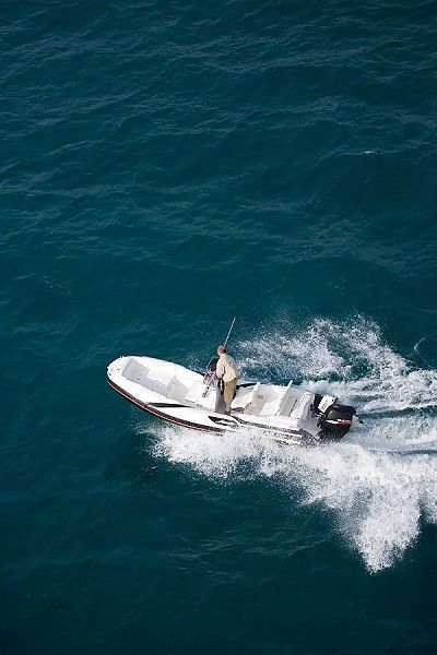 Un uomo sta pescando su una piccola barca nell'oceano.