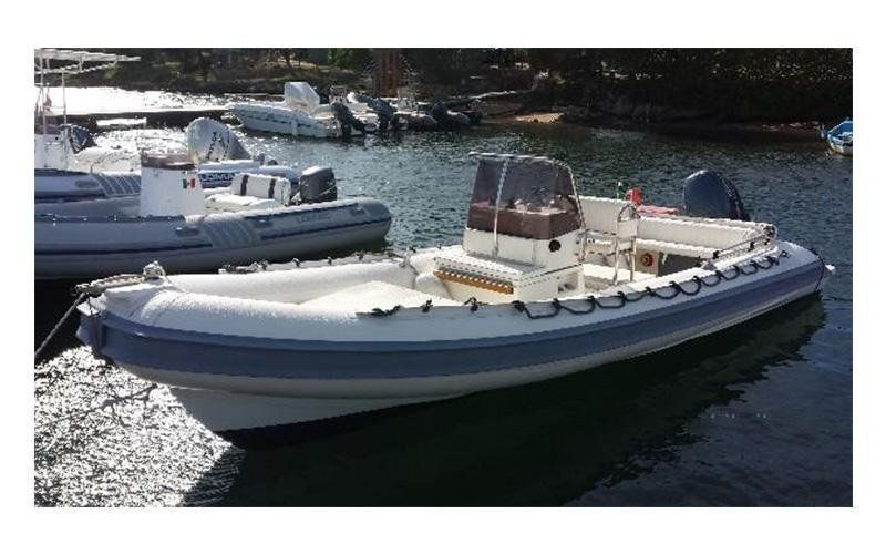 Una barca bianca e blu galleggia sulla superficie di uno specchio d'acqua.