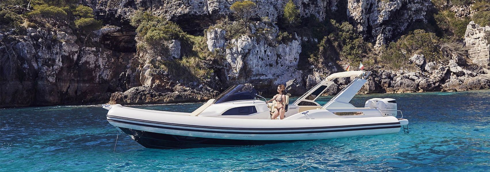 Una barca bianca galleggia sulla superficie di uno specchio d'acqua.