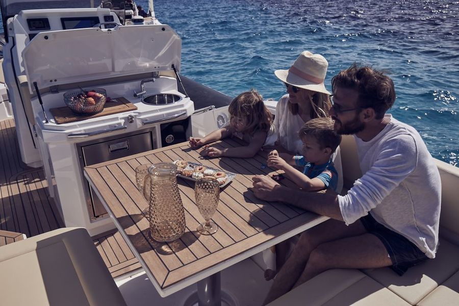 Una famiglia è seduta a un tavolo su una barca nell'oceano.
