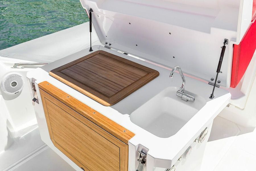 Una barca bianca con un tavolo di legno e un lavandino sul retro.
