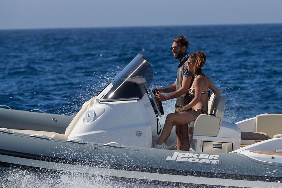 Un uomo e una donna stanno navigando su una barca a vela nell'oceano.