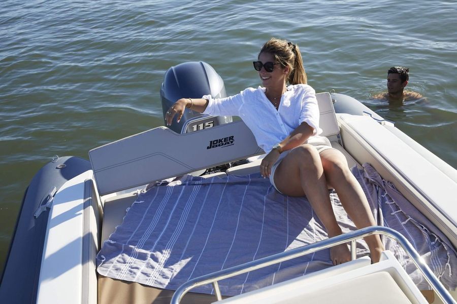 Una donna è seduta sul retro di una barca in acqua.