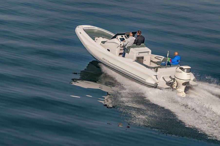 Una barca bianca galleggia sulla superficie di uno specchio d'acqua.