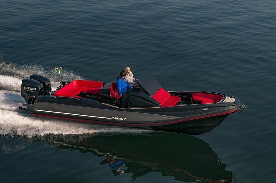 Una barca rossa e nera galleggia sulla superficie di uno specchio d'acqua.