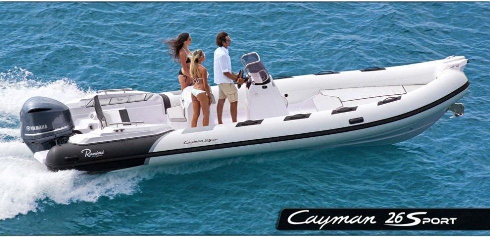 Un uomo e due donne sono su una barca sportiva Cayman 26