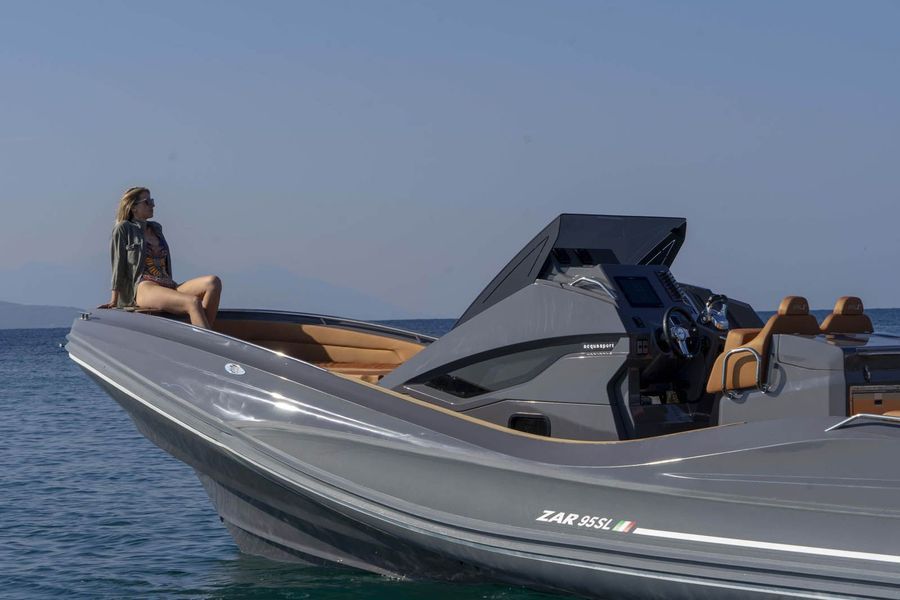 Una donna è seduta sul bordo di una barca nell'oceano.