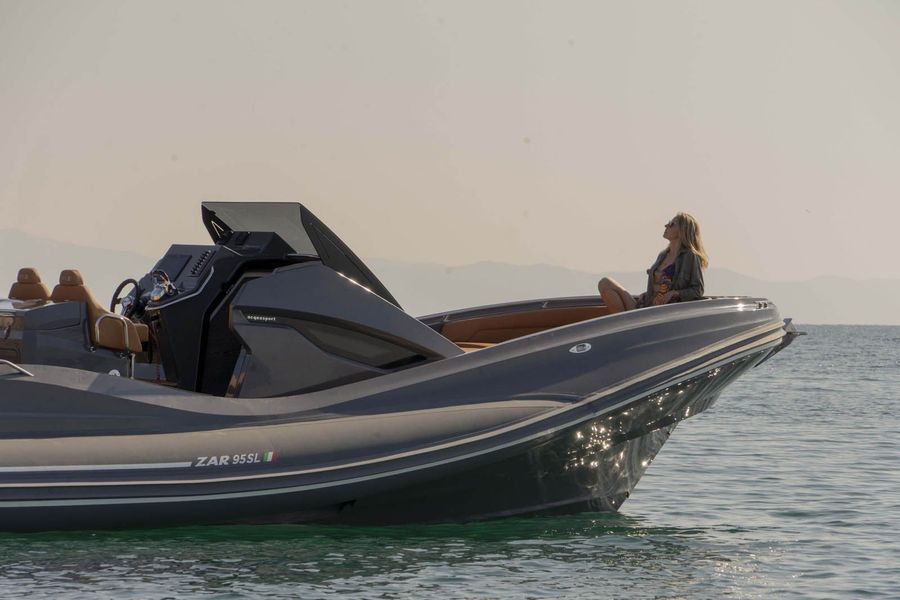 Una donna è seduta sulla prua di una barca nell'oceano.