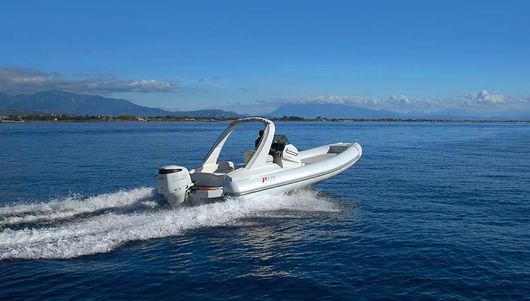 Una barca bianca galleggia su una grande distesa d'acqua.