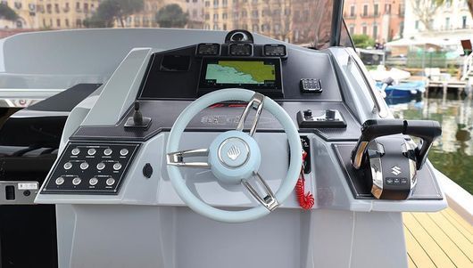 Il volante di una barca è appoggiato su un ponte di legno.