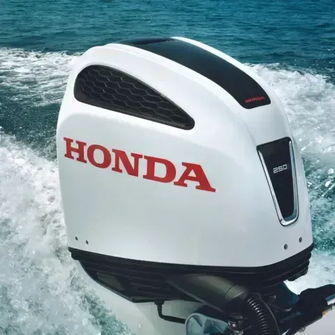 Un motore fuoribordo Honda bianco galleggia nell'acqua