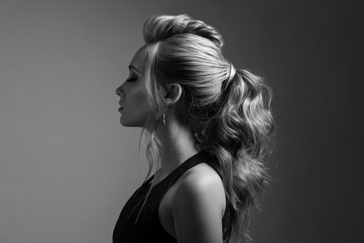 A black and white photo of a woman with long hair in a ponytail.