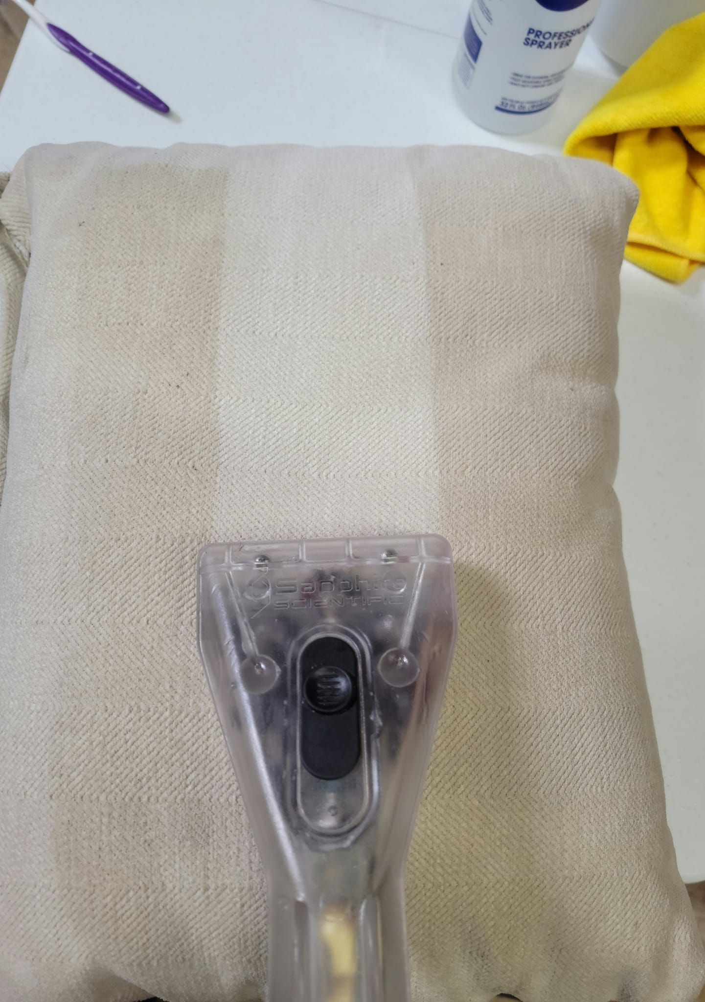 A pillow is being cleaned with a vacuum cleaner.