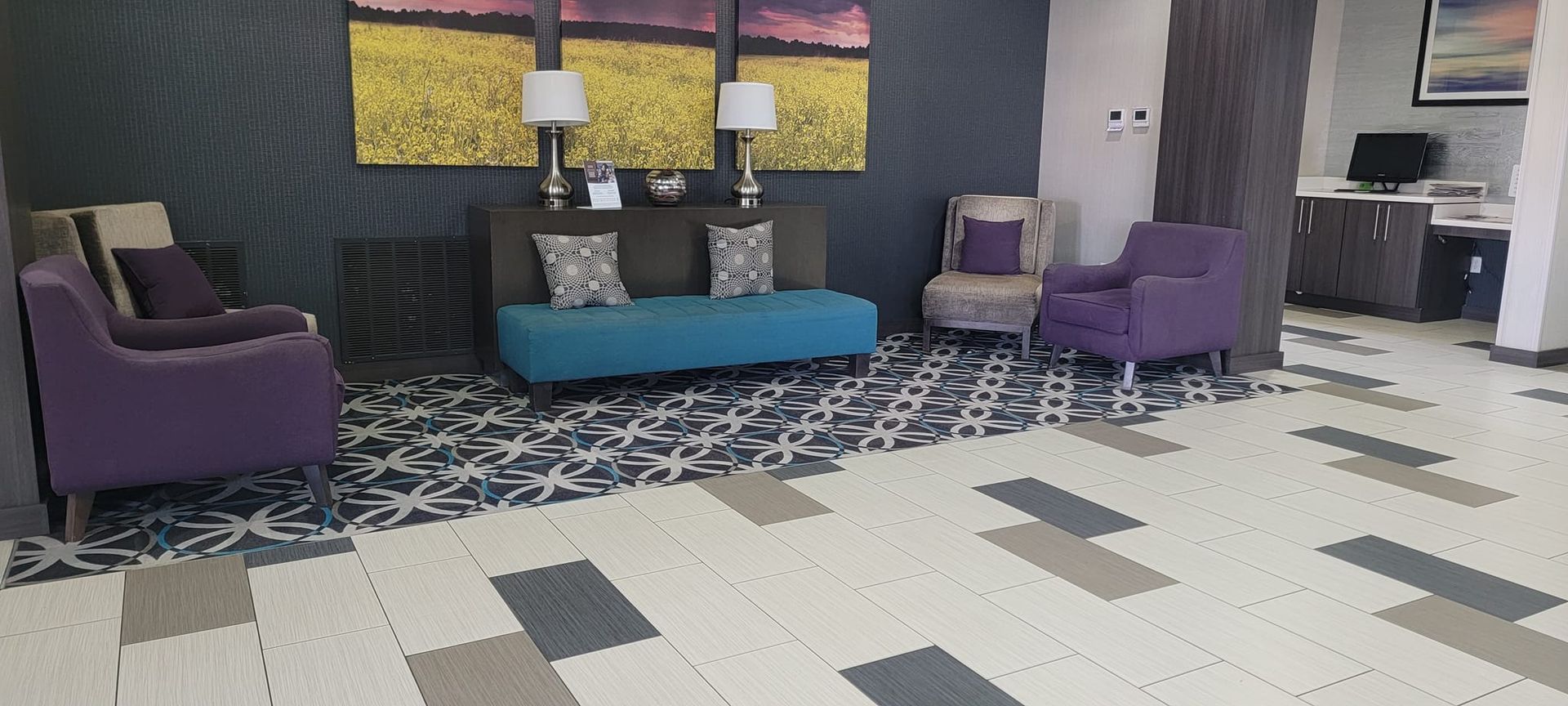A hotel lobby with purple chairs and a blue couch.
