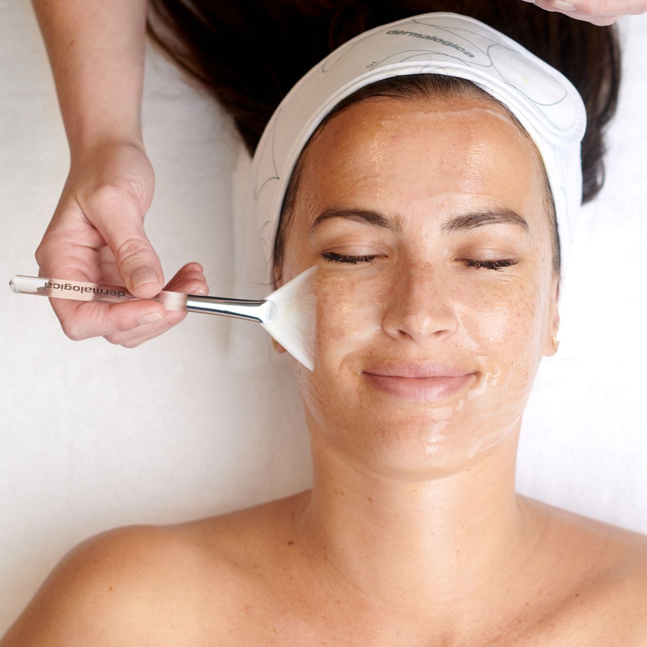 Eine Frau bekommt eine Gesichtsbehandlung mit einer Bürste im Gesicht