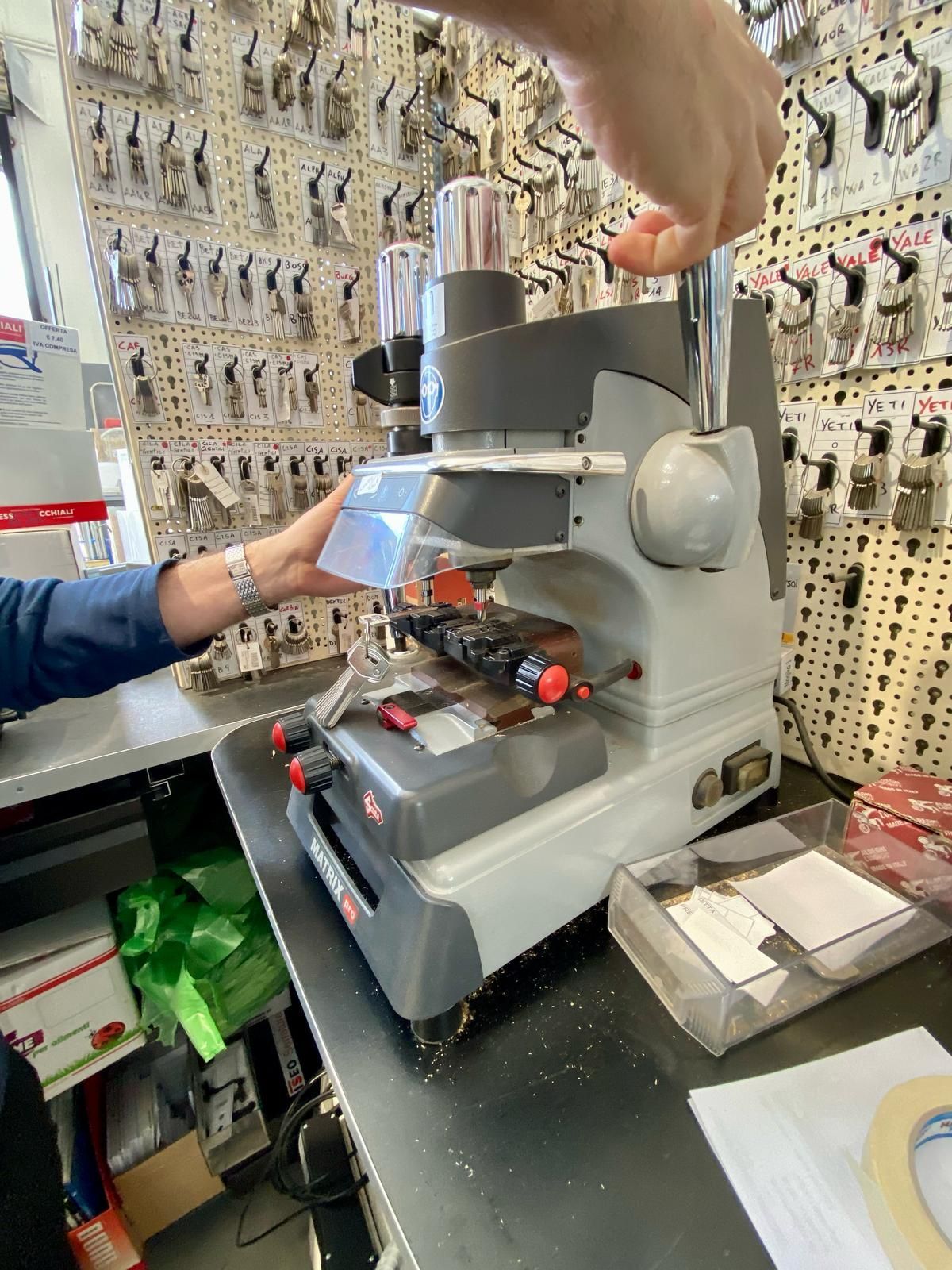 Una persona sta usando una macchina per realizzare chiavi in ​​un negozio di fabbro
