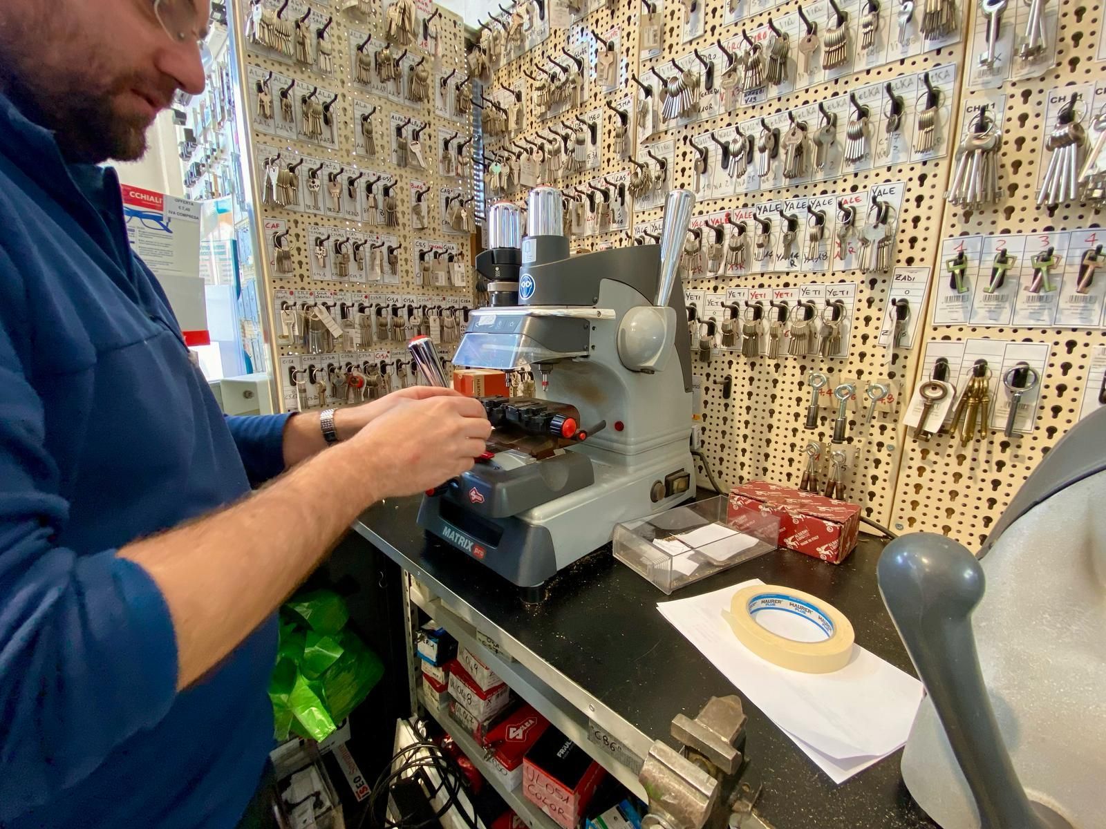 Un uomo sta lavorando su una macchina davanti a un muro di tasti