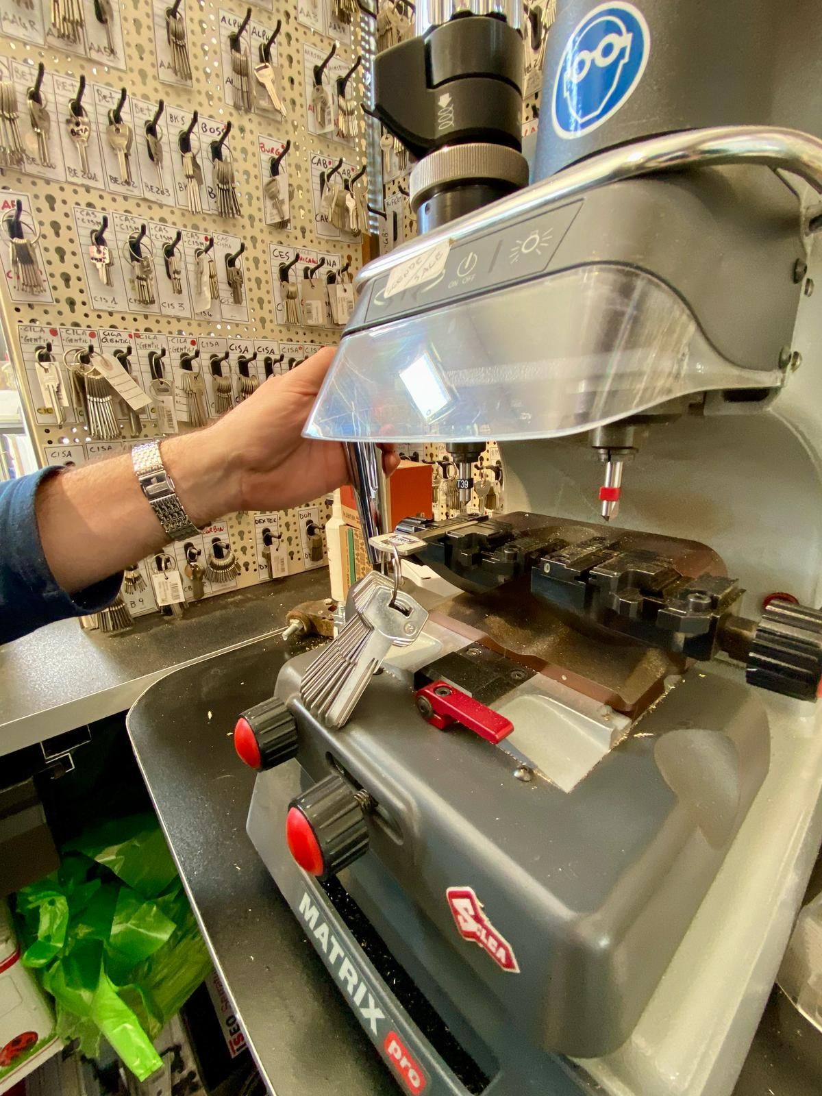 Una persona sta utilizzando una macchina per tagliare le chiavi in ​​una bottega di fabbro.