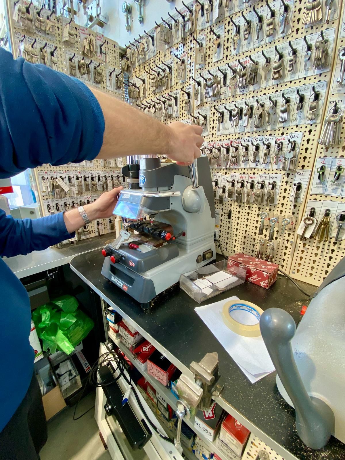 Un uomo sta lavorando su una macchina davanti a un muro di tasti
