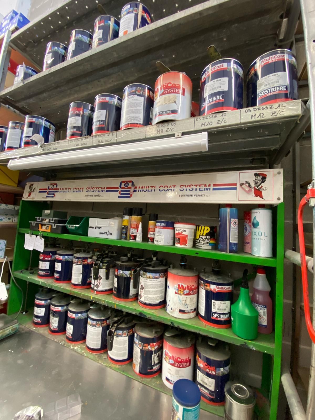 Uno scaffale pieno di una varietà di vernici e prodotti chimici