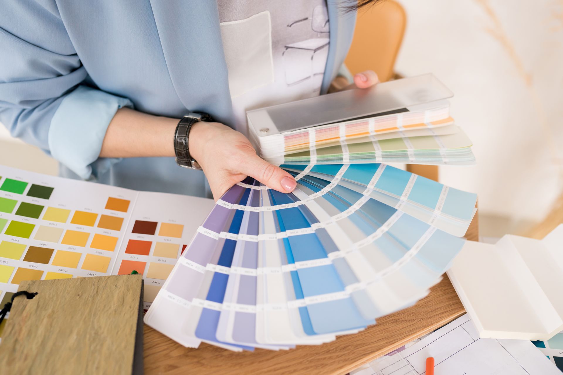 A woman is holding a fan of paint samples.