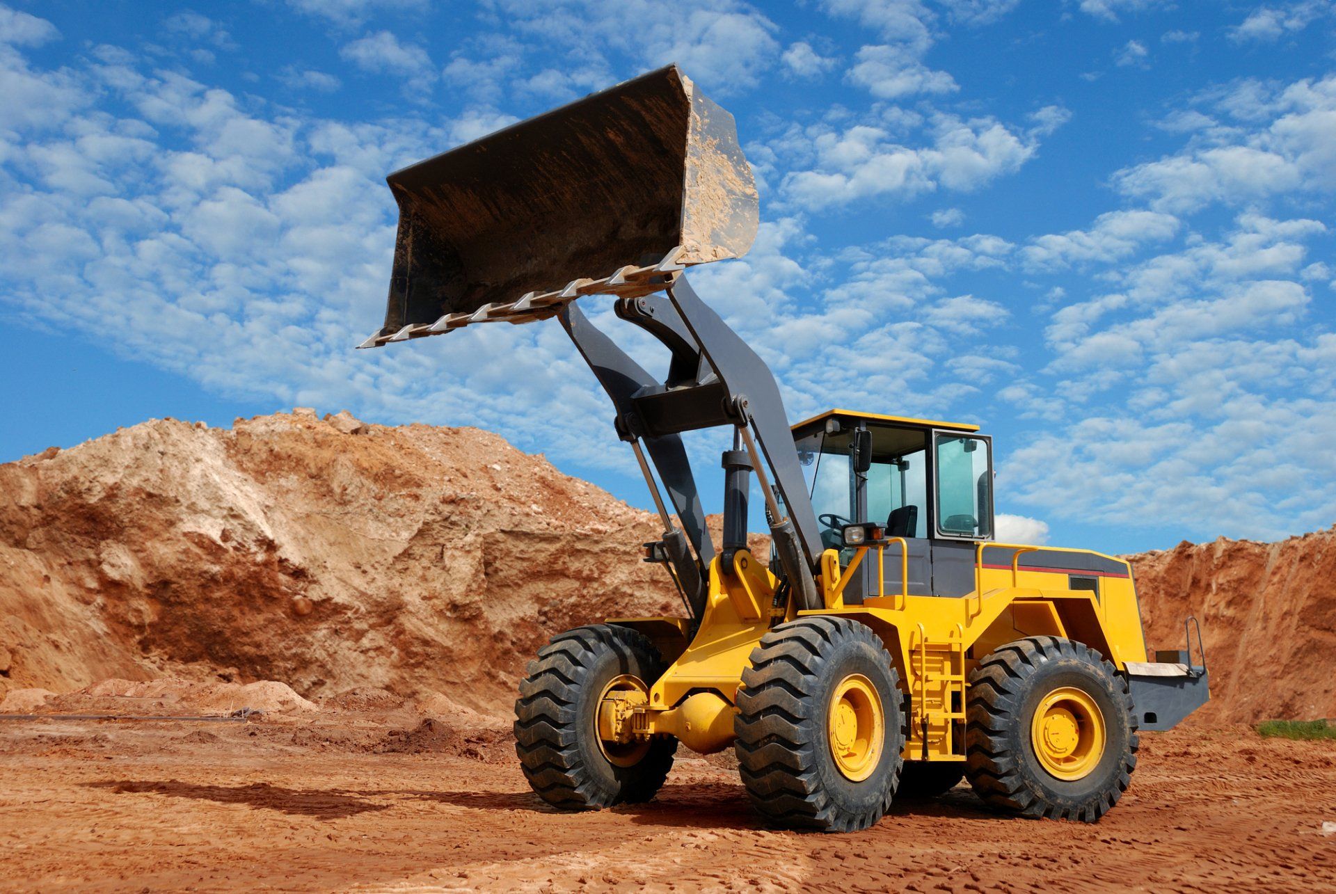 Large front end loader with bucket up high in Adelaide quarry.