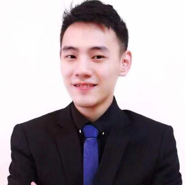A young man in a suit and tie is smiling for the camera.
