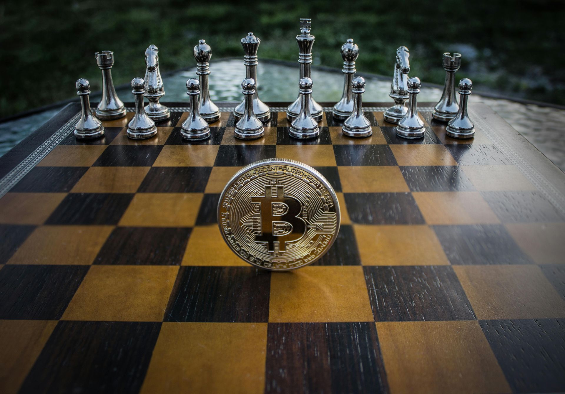 A coin with the letter b on it is on a chess board.