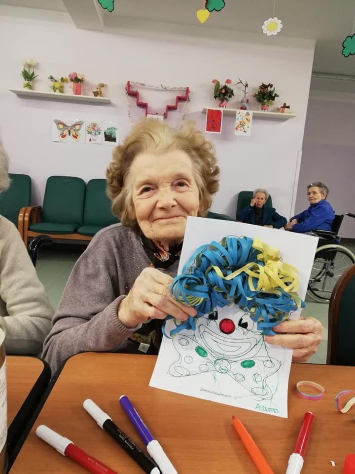 anziana ospite del centro con disegno in mano