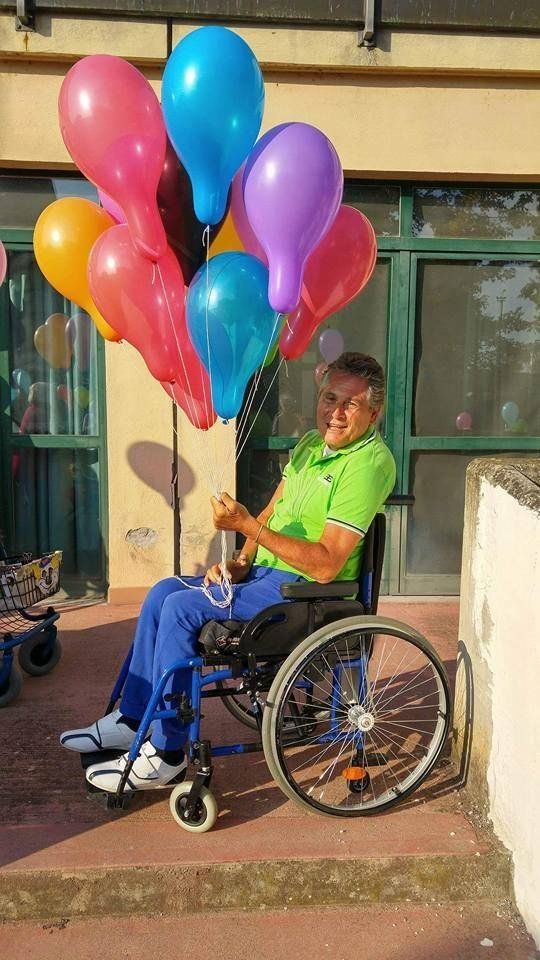 anziano ospite del centro con palloncini mentre festeggia