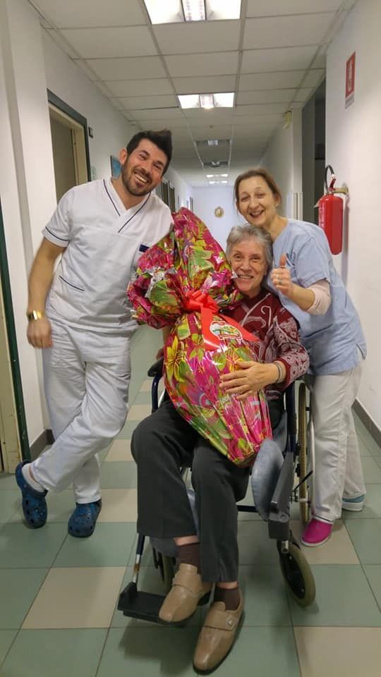 operatori del centro dopo aver regalato un uovo di pasqua gigante a una loro ospite